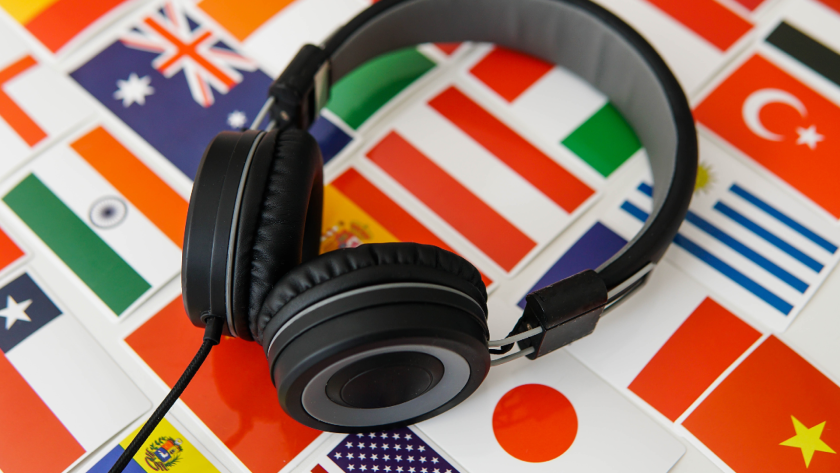 A collection of national flags printed on cards and laid out on a table, a pair of heads phones sit on top